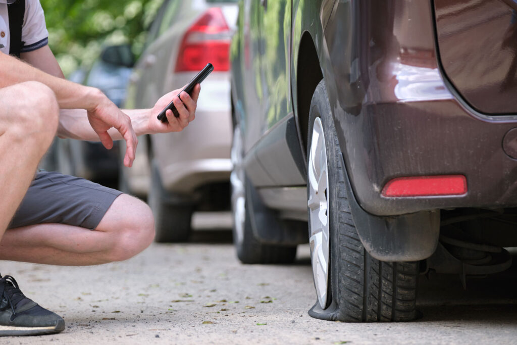 Driver with flat tire calling for roadside assistance