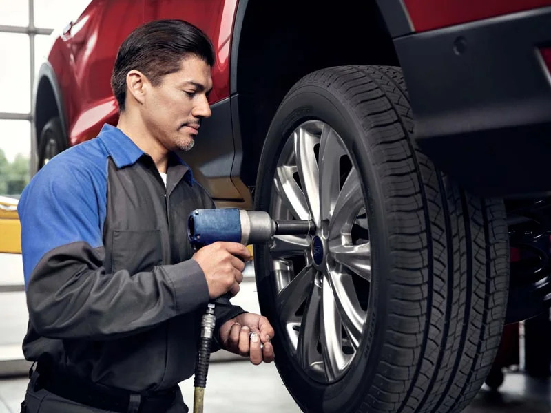 Technician performing tire maintenance and rotation
